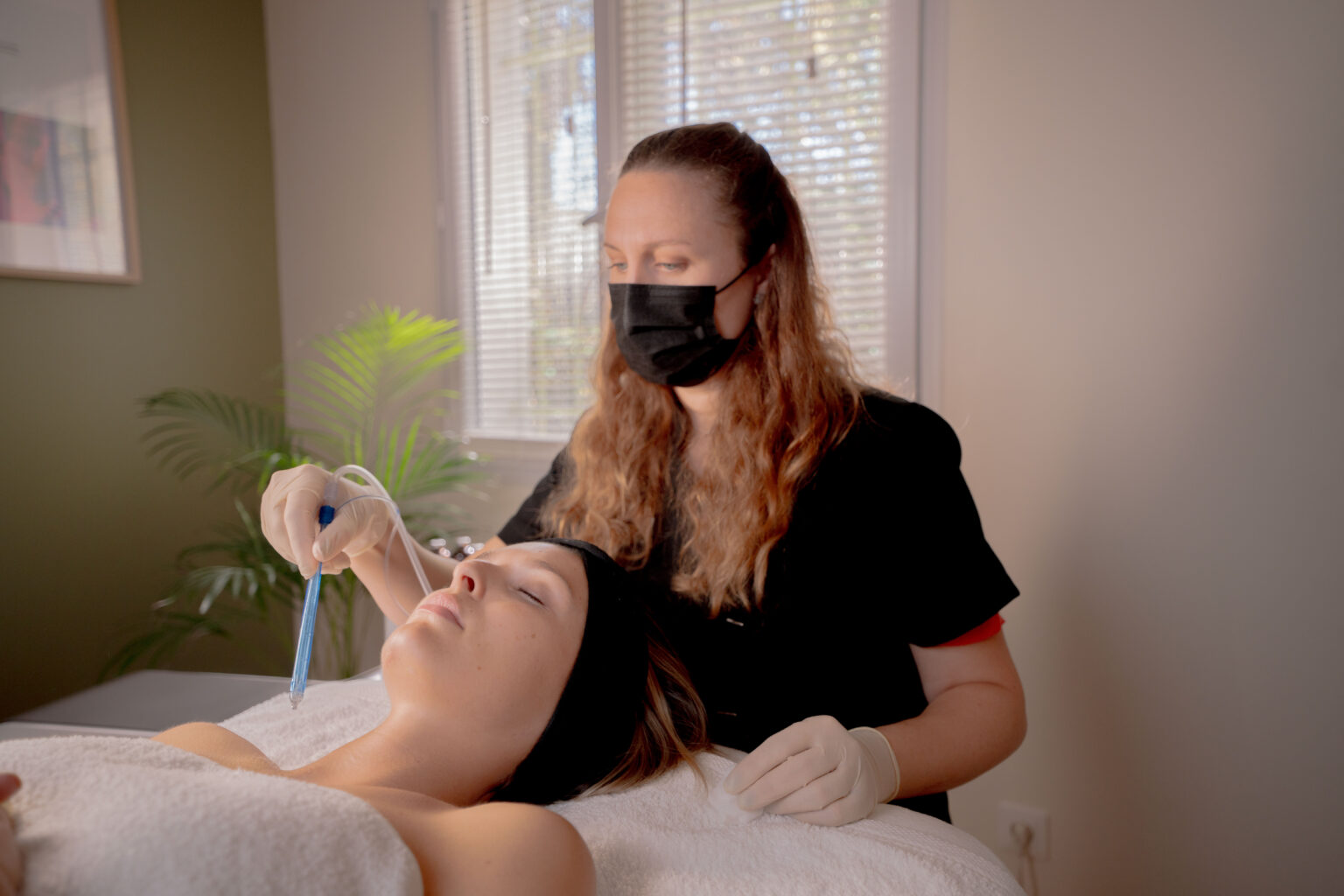 Soin du visage JetPeel réalisé par une praticienne sur une cliente allongée, dans une cabine lumineuse de Livaya